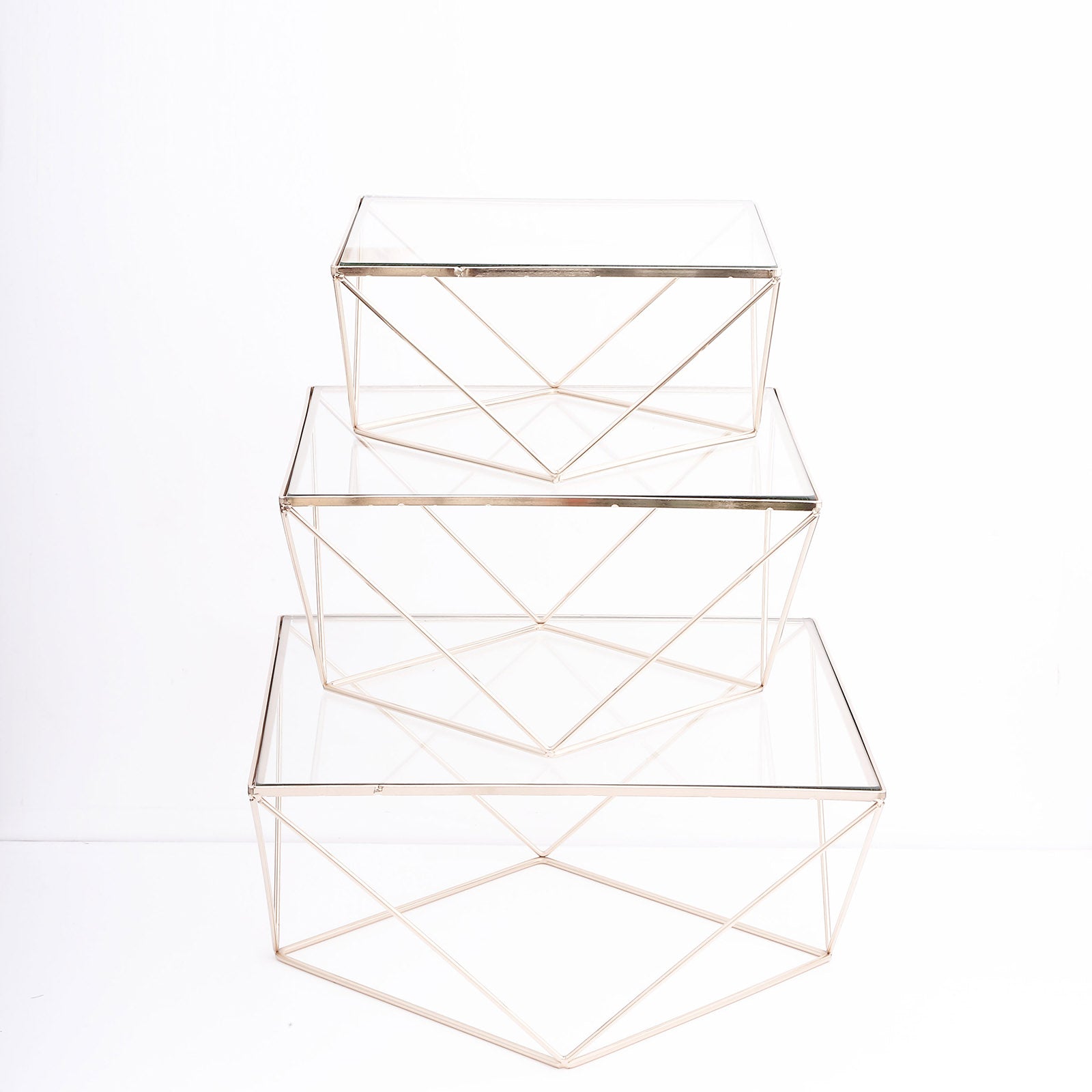 Gold geometric stackable cake stands with glass tops.