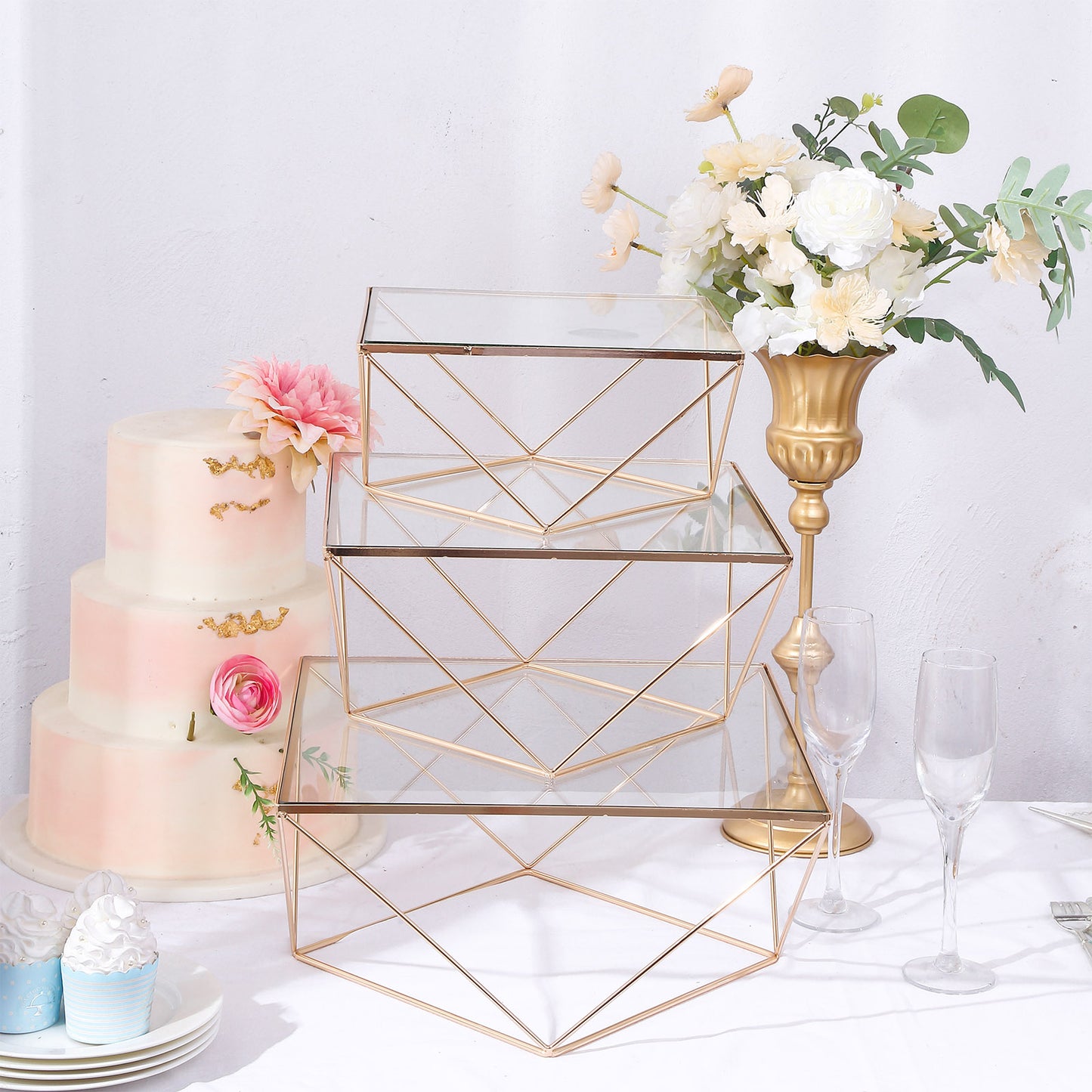 Gold geometric stackable cake stands with square glass tops.