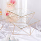 Gold geometric stackable cake stands with square glass tops.