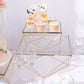 Gold geometric stackable dessert stands with square glass tops.
