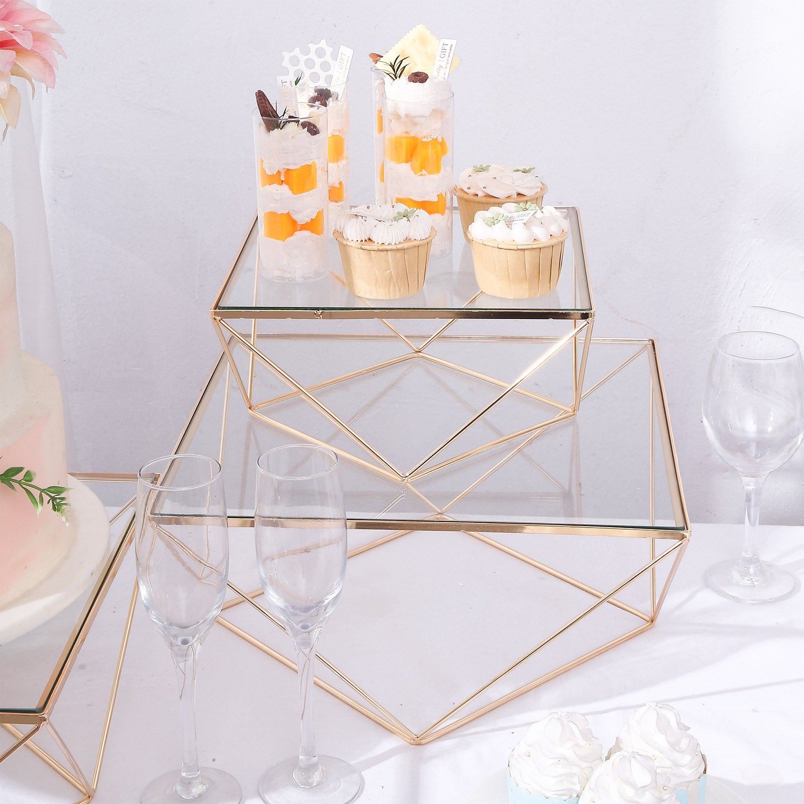 Gold geometric stackable dessert stands with square glass tops.