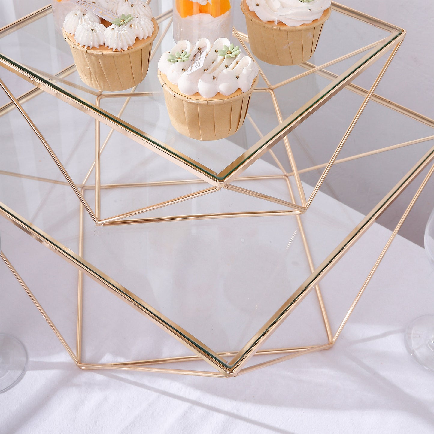Gold metal geometric stackable cake stand pedestals with glass tops.