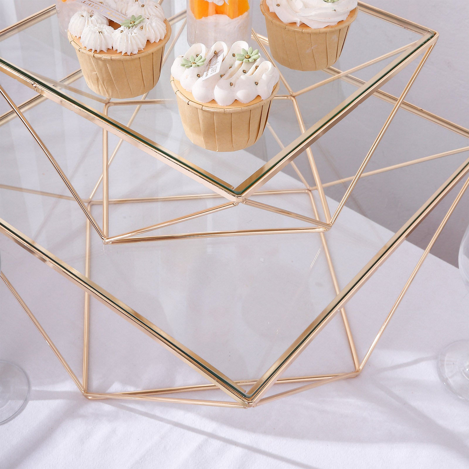 Gold metal geometric stackable cake stand pedestals with glass tops.