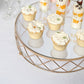 Gold geometric cake stand displaying cupcakes and desserts on a glass top.