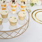 Gold geometric cake stand with glass top, displaying cupcakes and desserts.