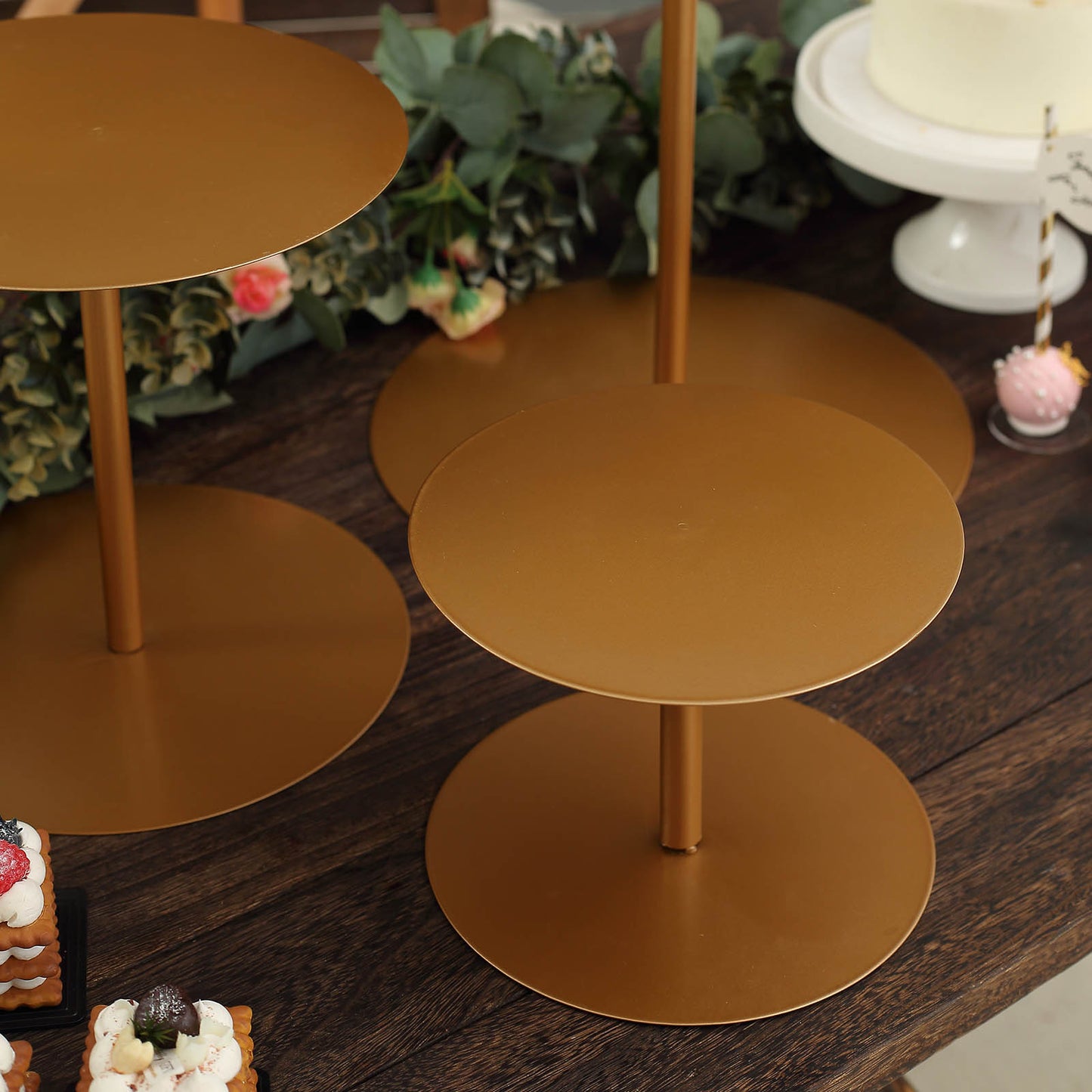 Gold metal round pedestal cupcake dessert stands set of 3 on a wooden table.