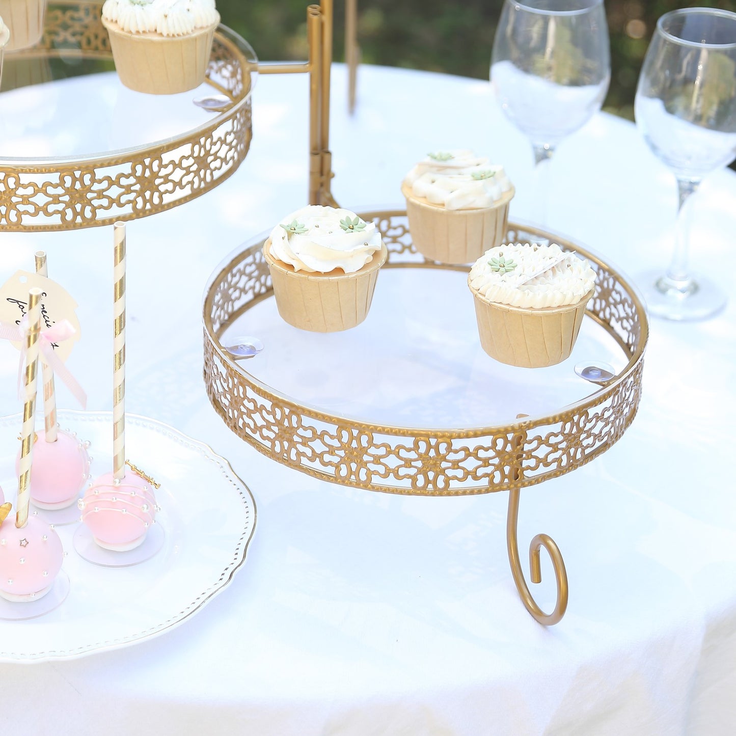 Gold rotating cake stand with clear acrylic plates and lace design, perfect for desserts.