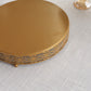 Gold metal round pedestal cake stand with decorative edge.