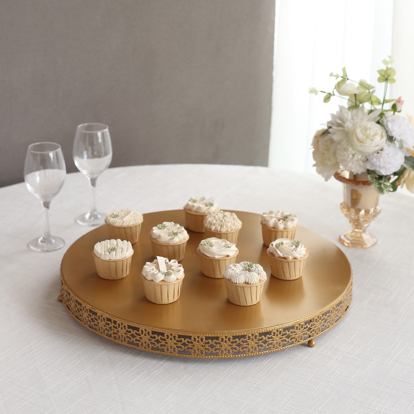 Gold metal Fleur De Lis cupcake stand displaying desserts.