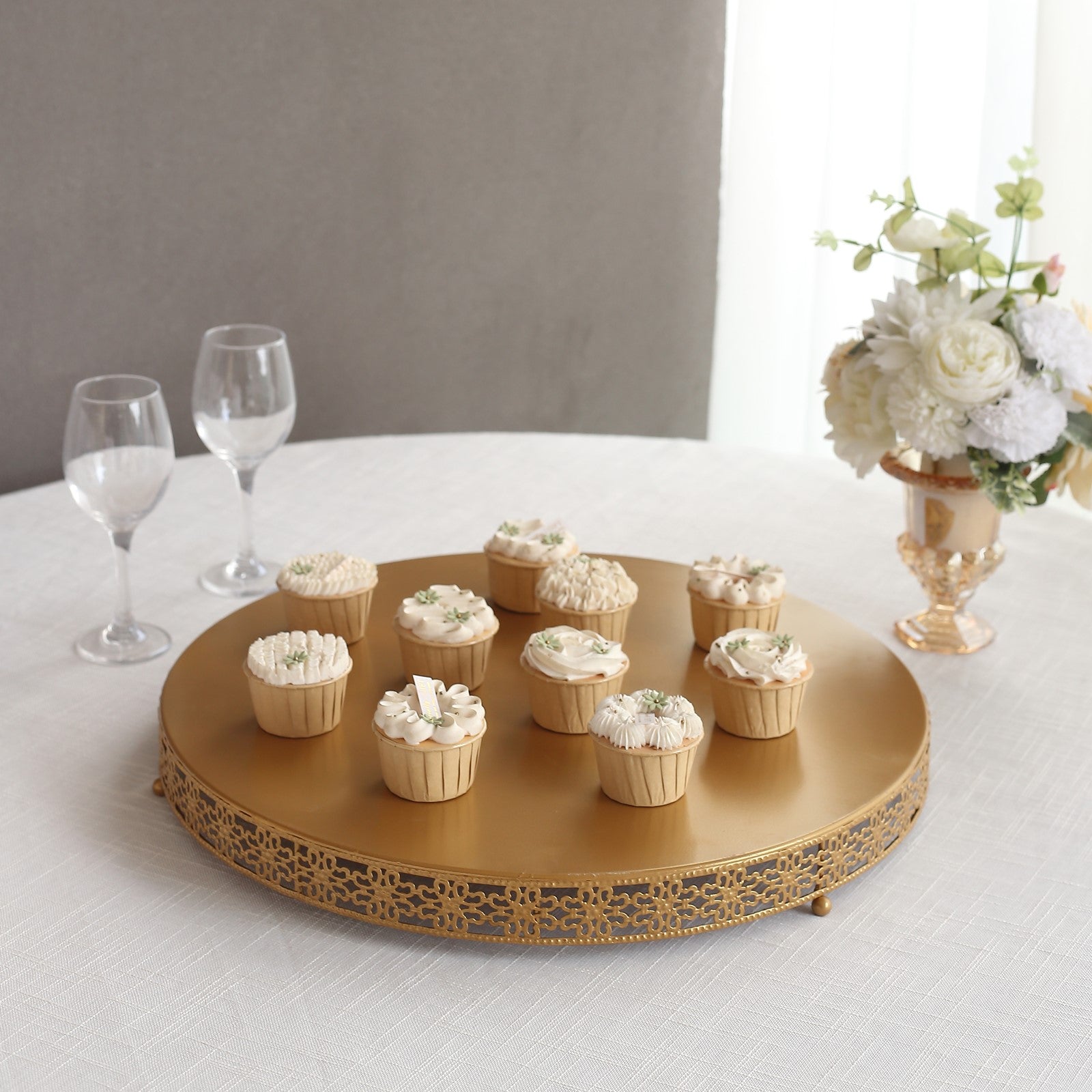 Gold metal Fleur De Lis cupcake stand displaying desserts.