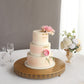 Gold metal round pedestal cake stand with a floral cake centerpiece.