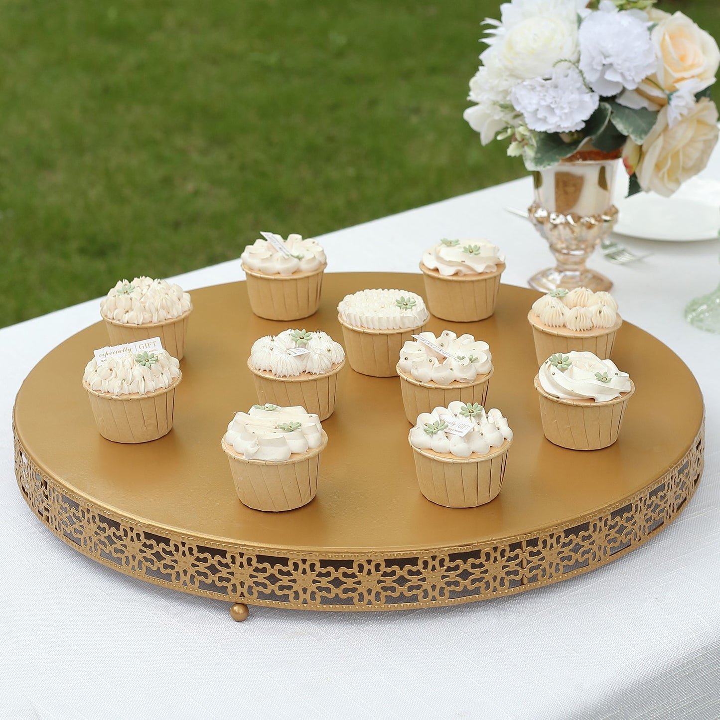 Gold metal cupcake display stand with elegant desserts on top.