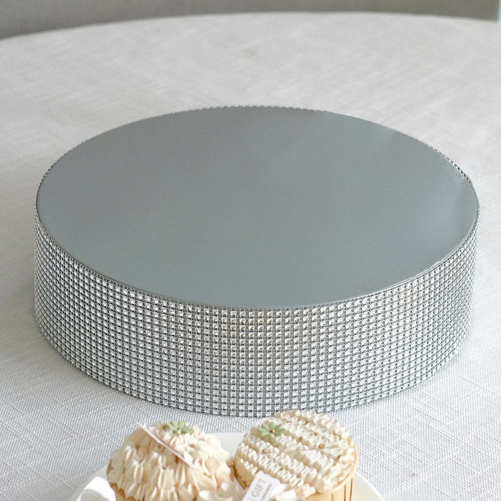 Silver round metal pedestal cake stand with rhinestones.