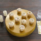 Gold round metal pedestal cake stand with cupcakes displayed on top.