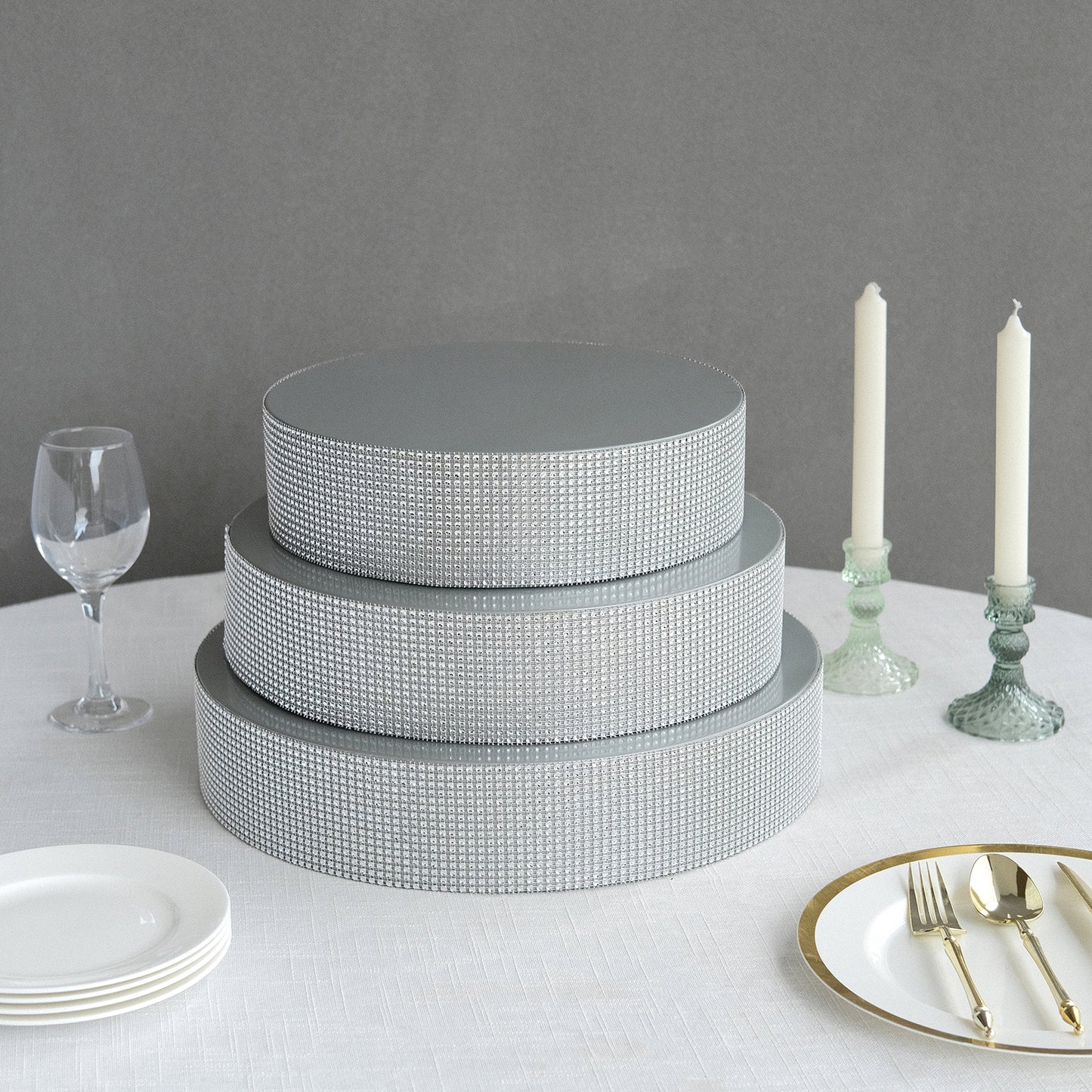 Silver rhinestones round metal cake stand centerpiece on a table.