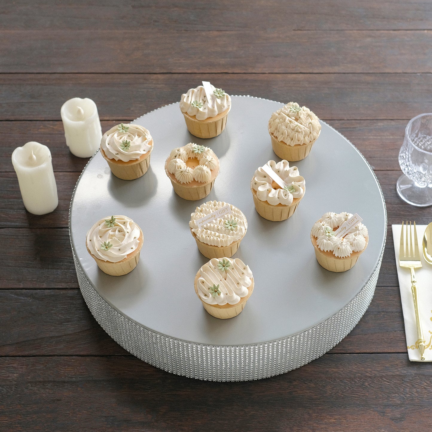 Silver round metal pedestal cake stand with cupcakes, rhinestone accents.