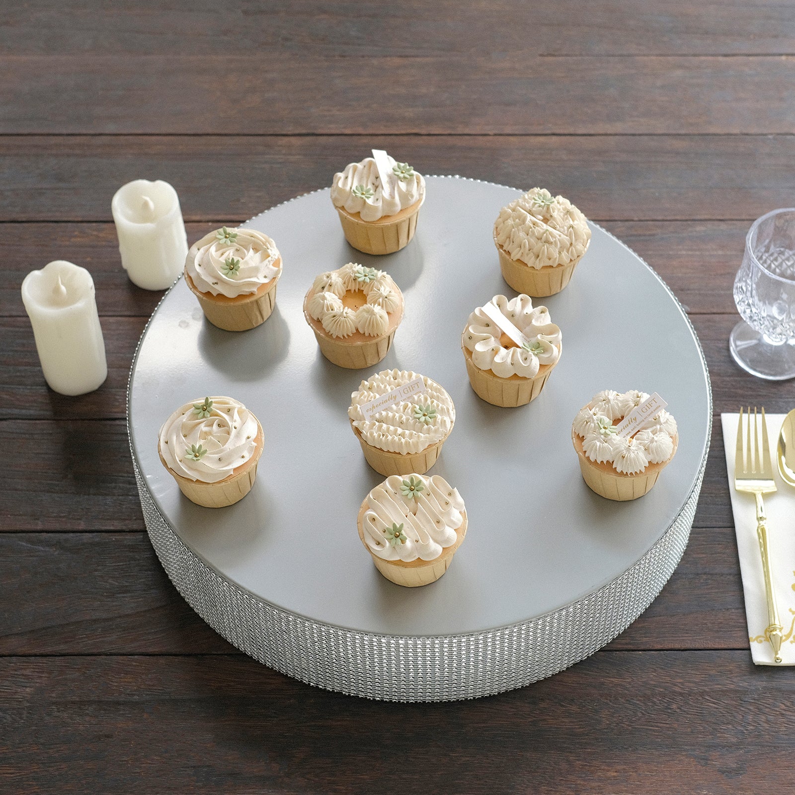 Silver round metal pedestal cake stand with cupcakes, rhinestone accents.