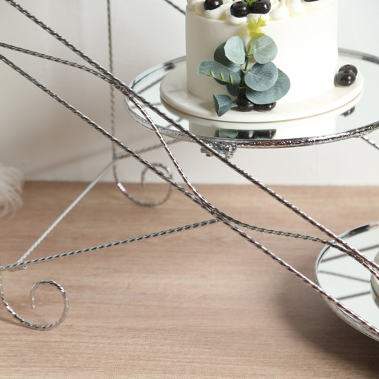 Silver 3-tier cupcake stand with round mirror trays for desserts.