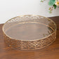 Gold ornate cake stand with glass top, perfect for dessert display.