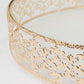 Gold metal cake stand with glass top, round ornate dessert display tray.