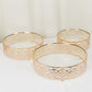 Gold ornate metal cake stands with glass tops, stackable for dessert display.