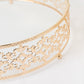 Gold ornate metal cake stand with glass top, perfect for dessert displays.