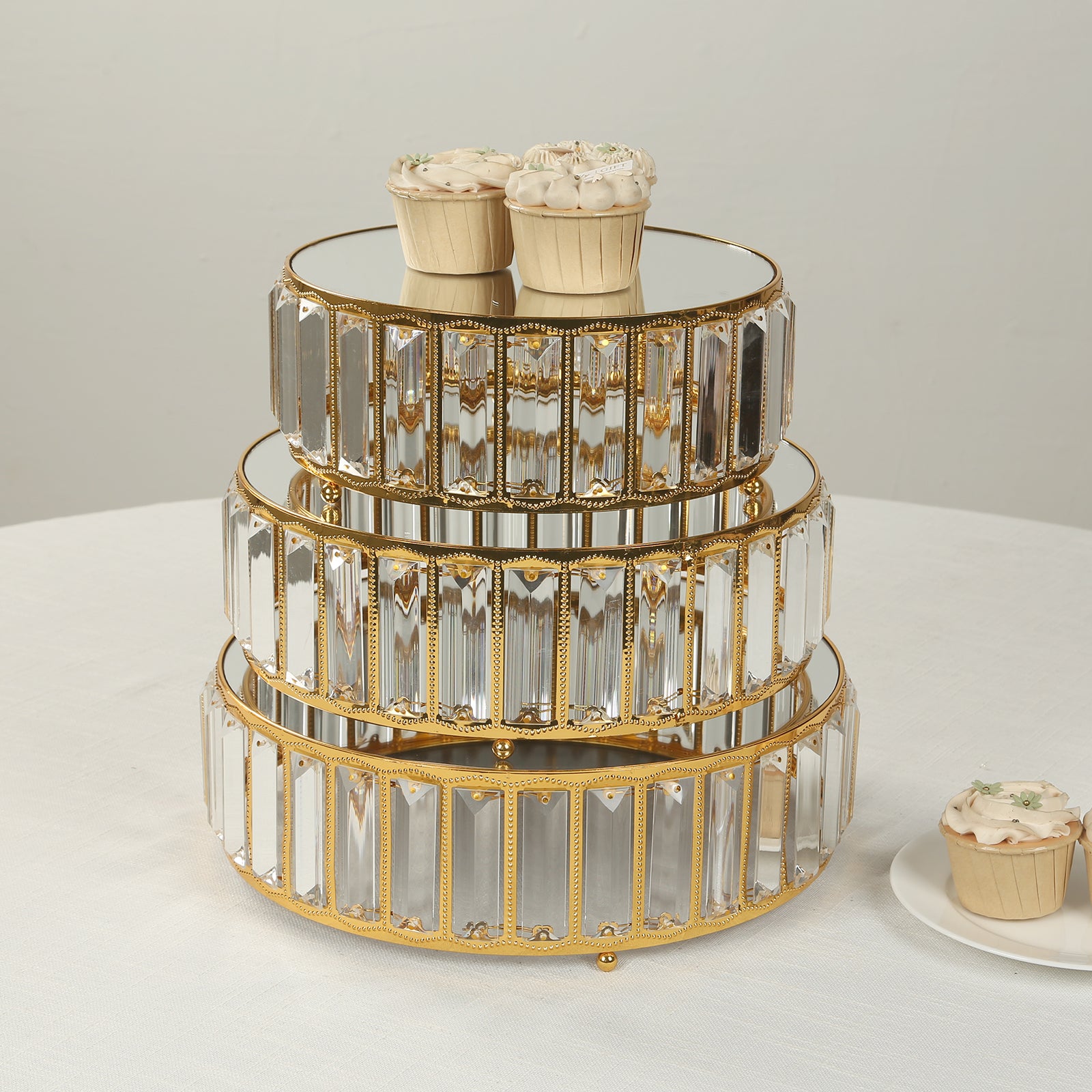 Gold metal crystal pendant cake stands with mirror tops, stackable dessert display trays.