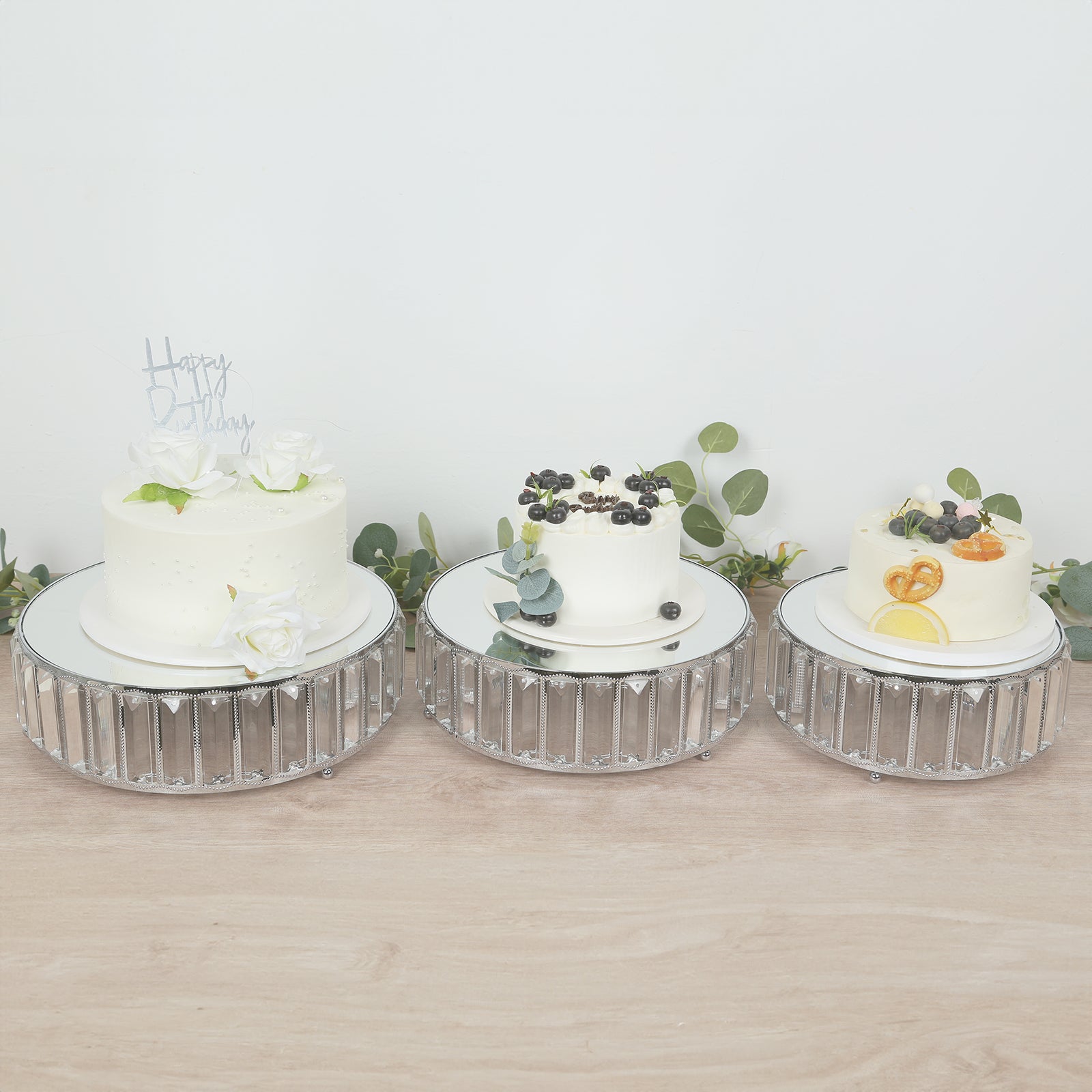Silver metal crystal pendant cake stands with mirror tops, stackable dessert trays.