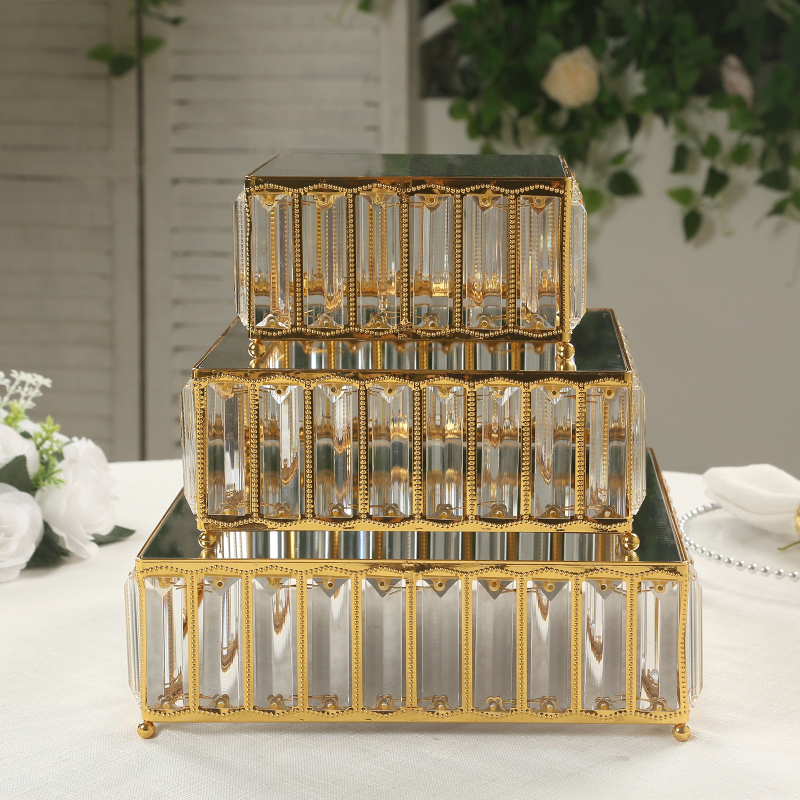 Gold metal crystal pendant cake stands with mirror tops, stackable dessert trays.