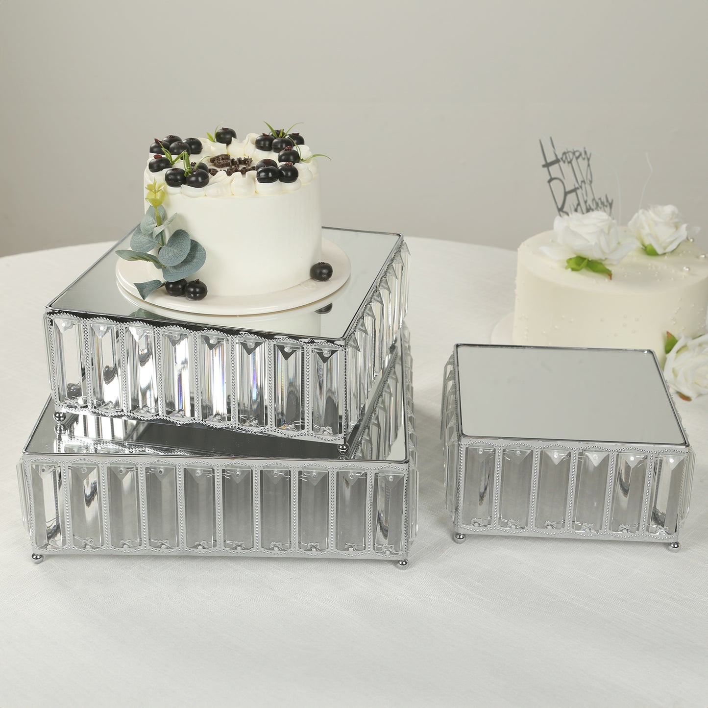 Silver metal crystal pendant cake stands with mirror tops, stackable dessert trays.