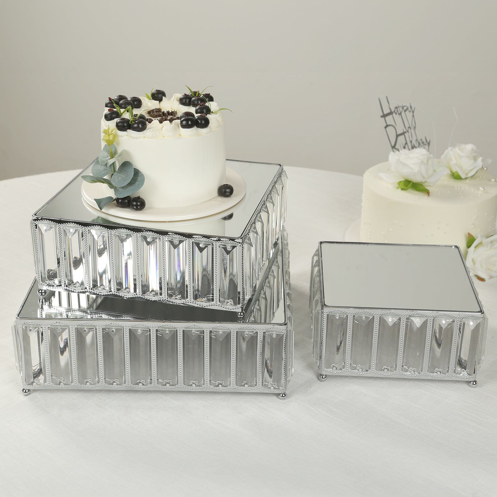 Silver metal crystal pendant cake stands with mirror tops, stackable dessert trays.