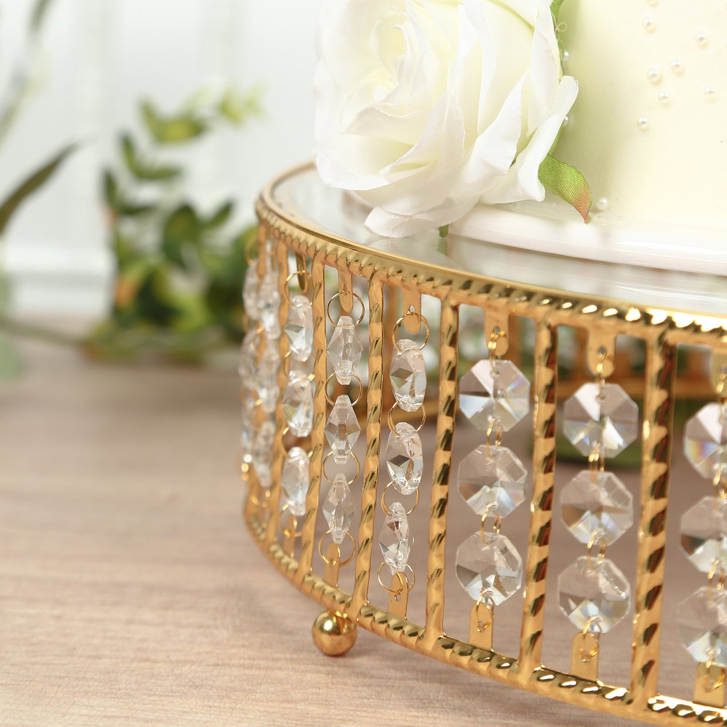 Gold cake stand with hanging crystal beads and glass top.