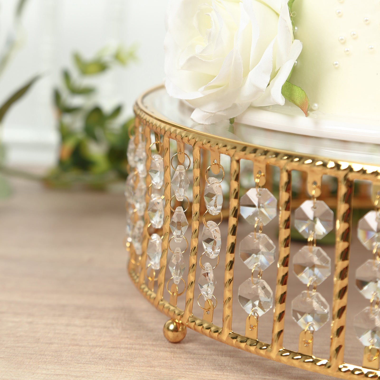 Gold cake stand with hanging crystal beads and glass top.
