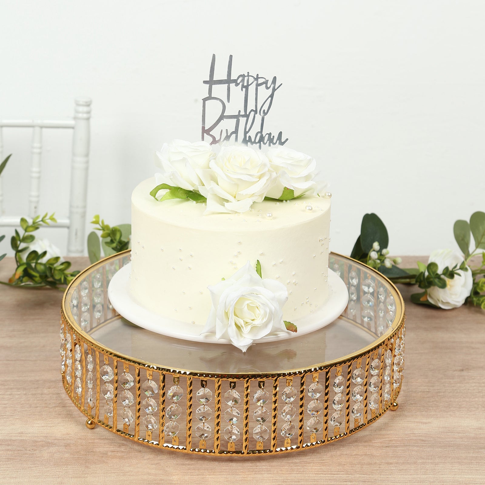 Gold cake stand with hanging crystal beads and glass top, perfect for desserts.