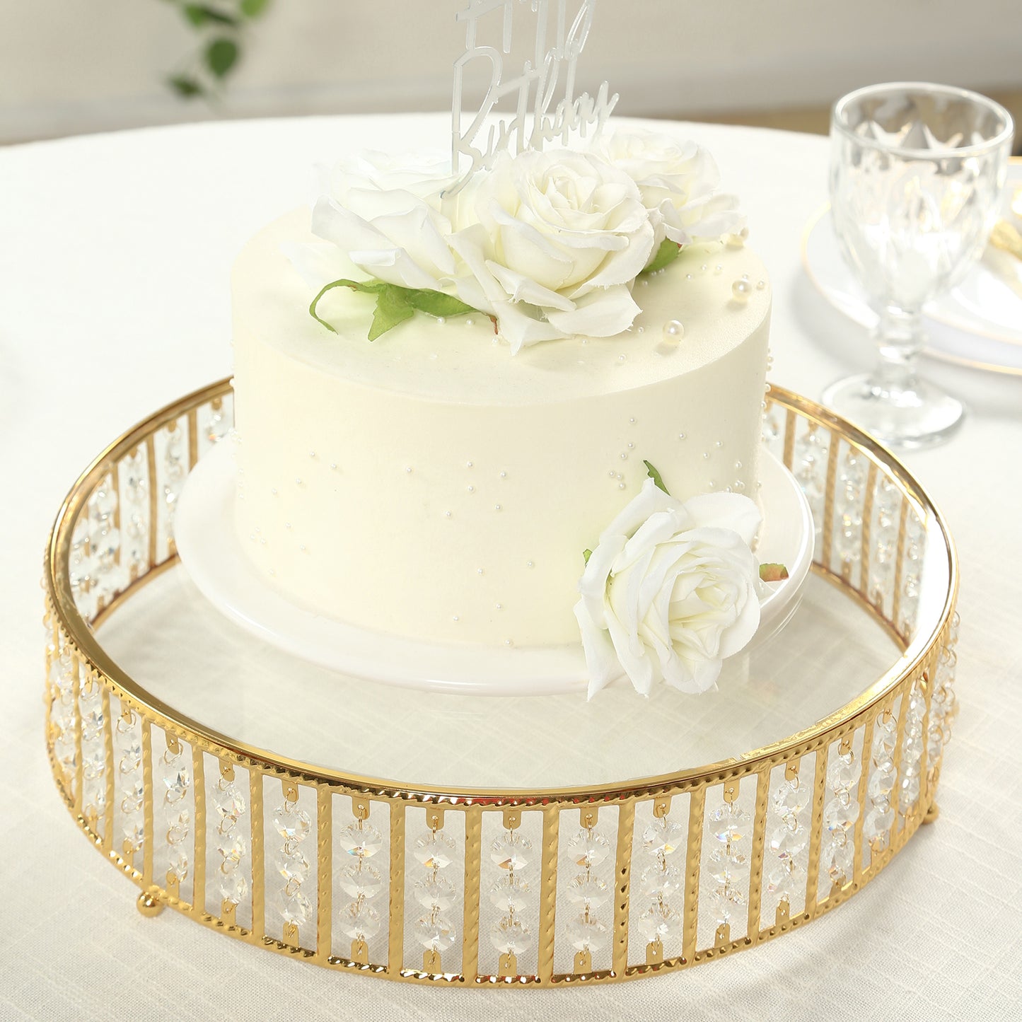 Gold round cake stand with hanging crystal beads and glass top.