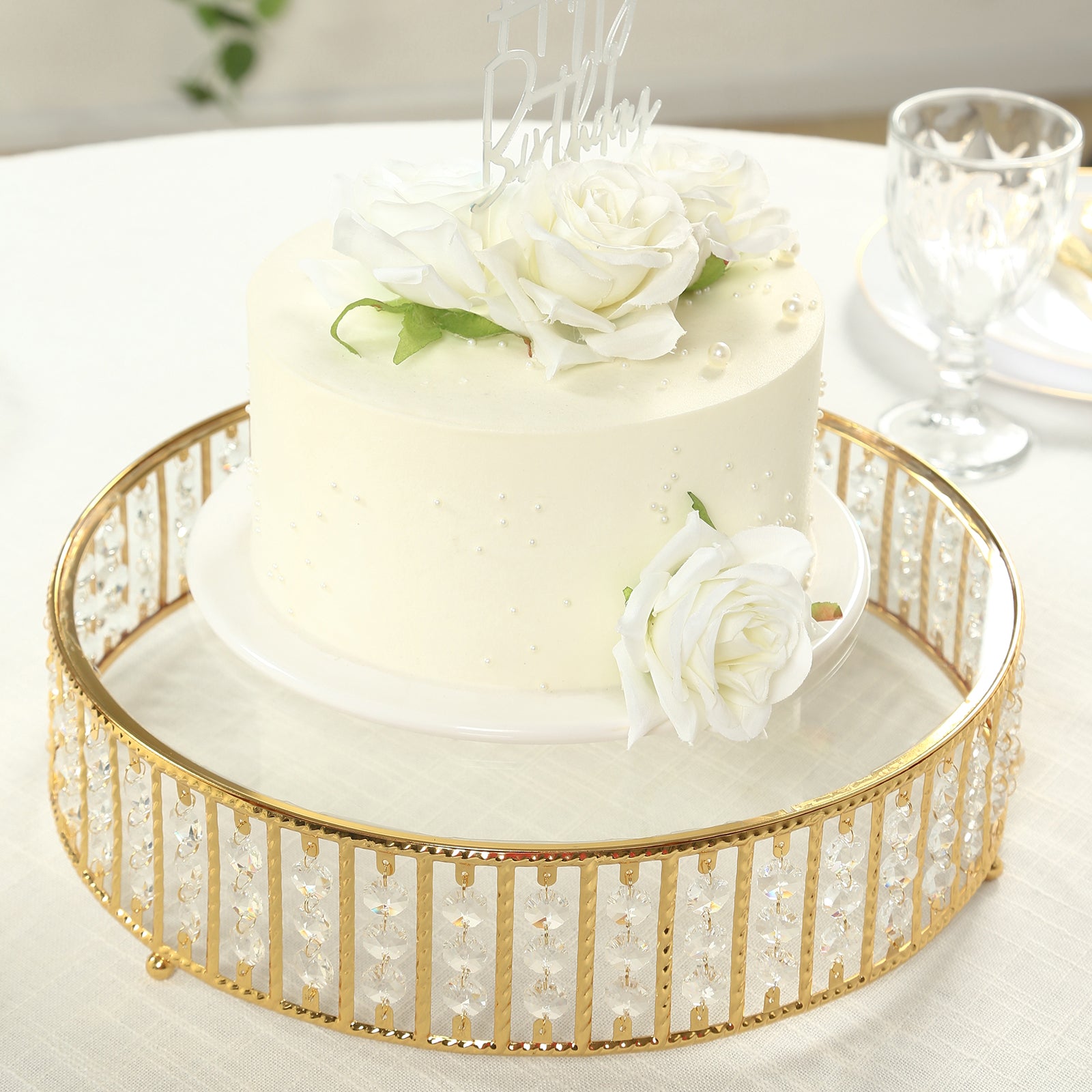 Gold round cake stand with hanging crystal beads and glass top.