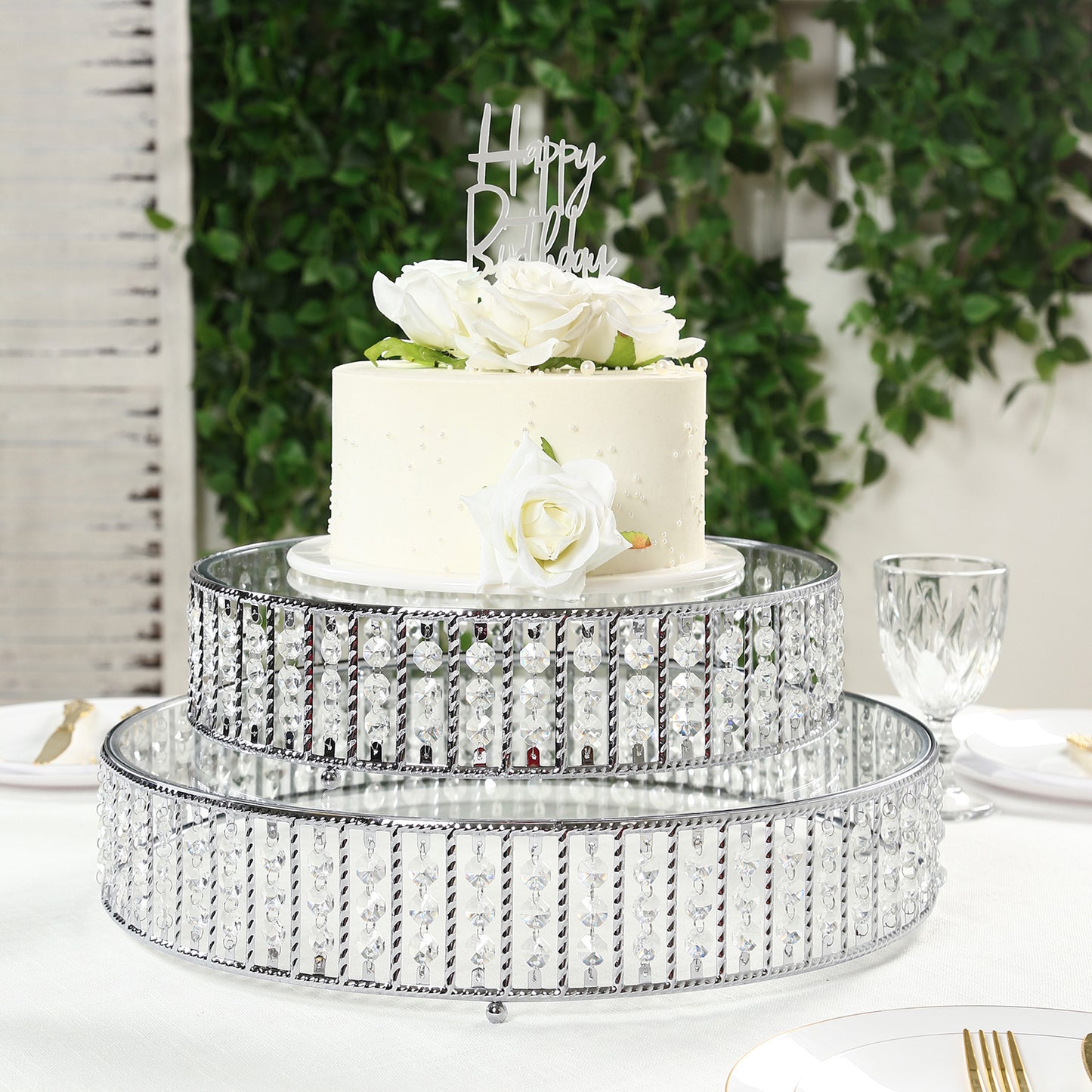 Silver cake stand with hanging crystal beads and glass top, perfect for desserts.