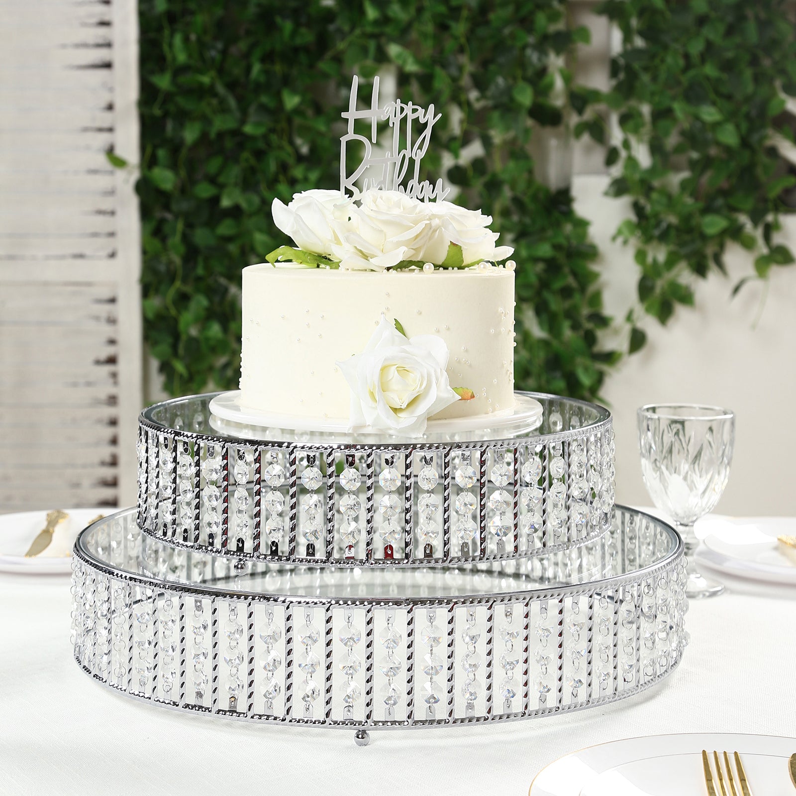 Silver cake stand with hanging crystal beads and glass top, perfect for desserts.