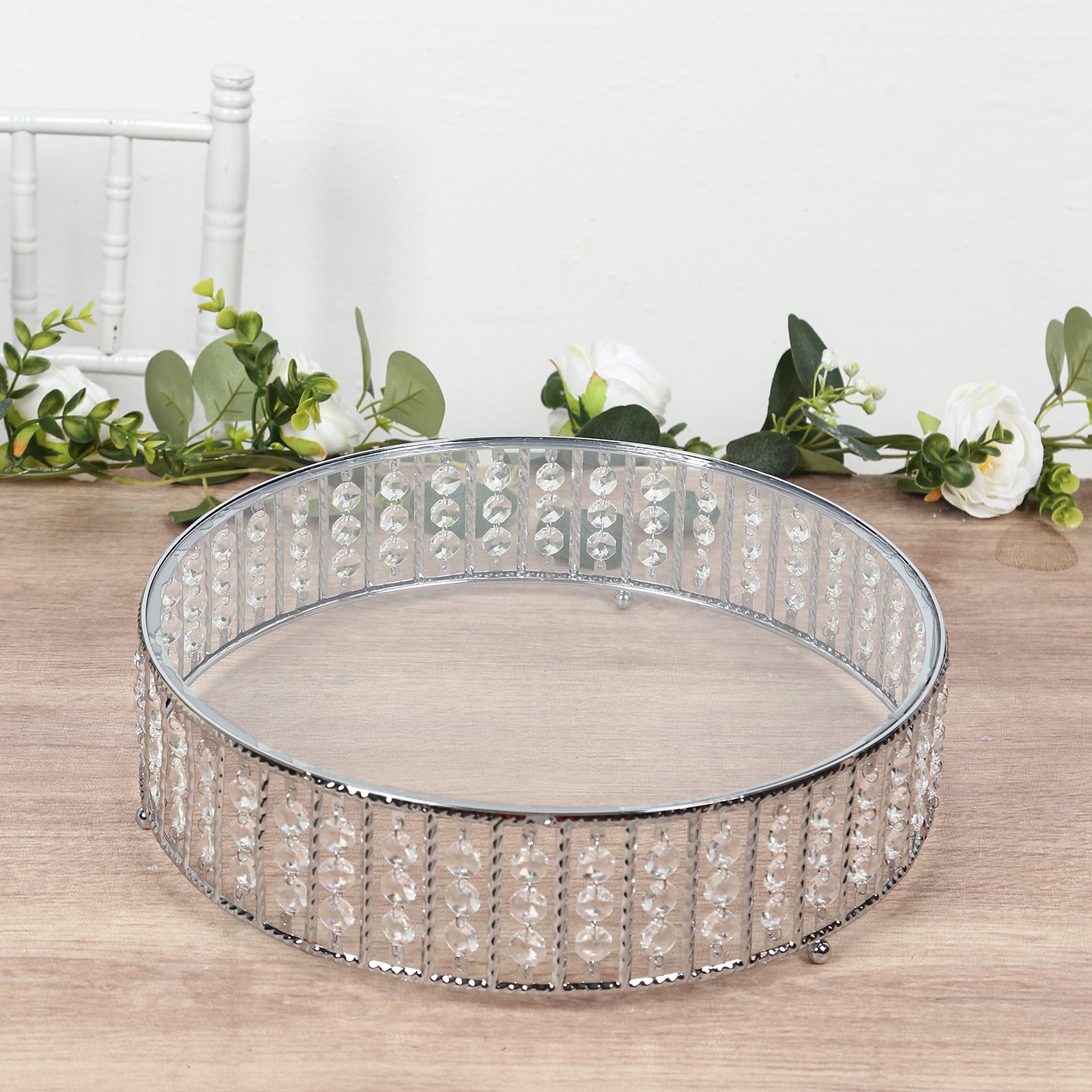 Silver round cake stand with hanging crystal beads and glass top.