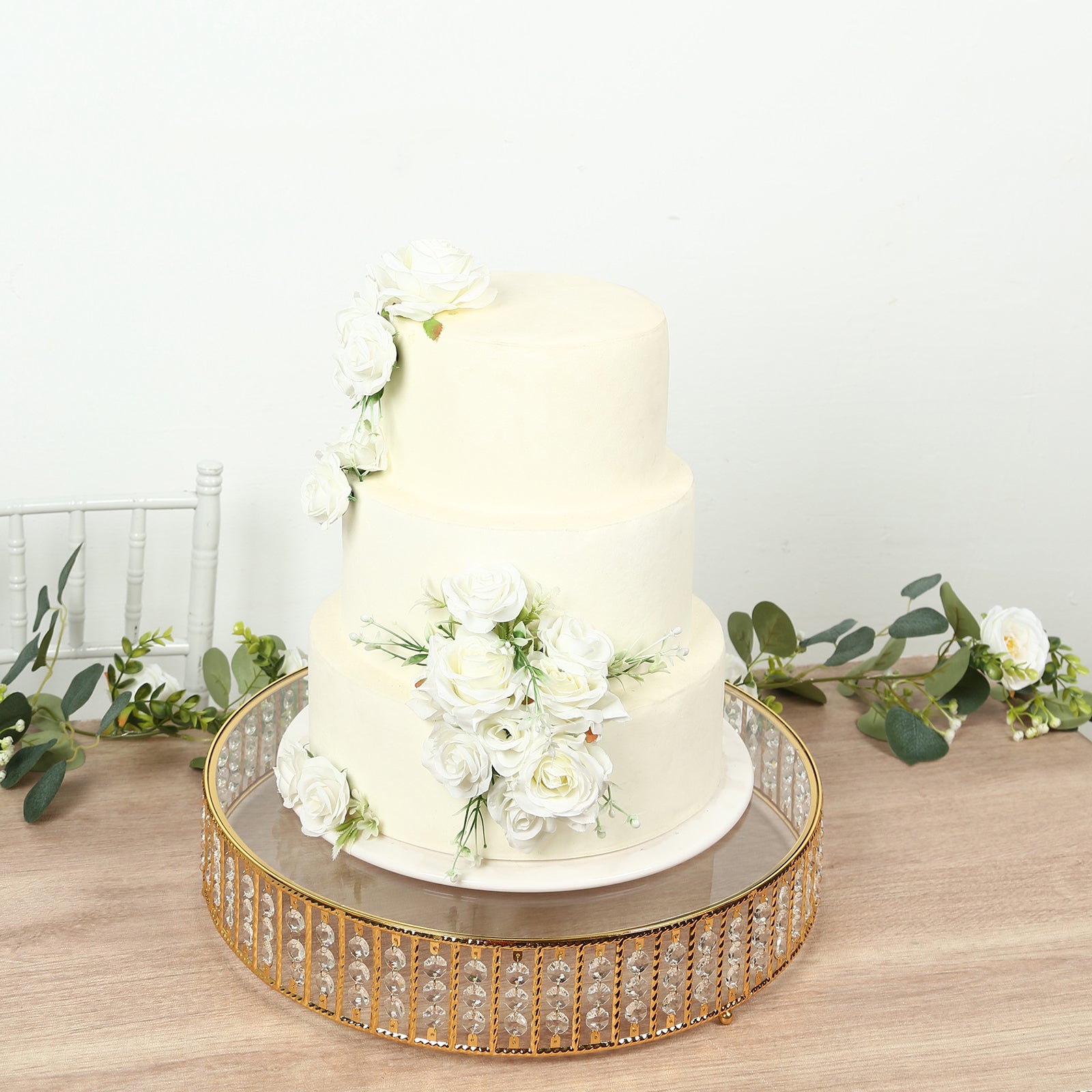 Gold round cake stand with crystal beads and glass top, perfect for desserts.