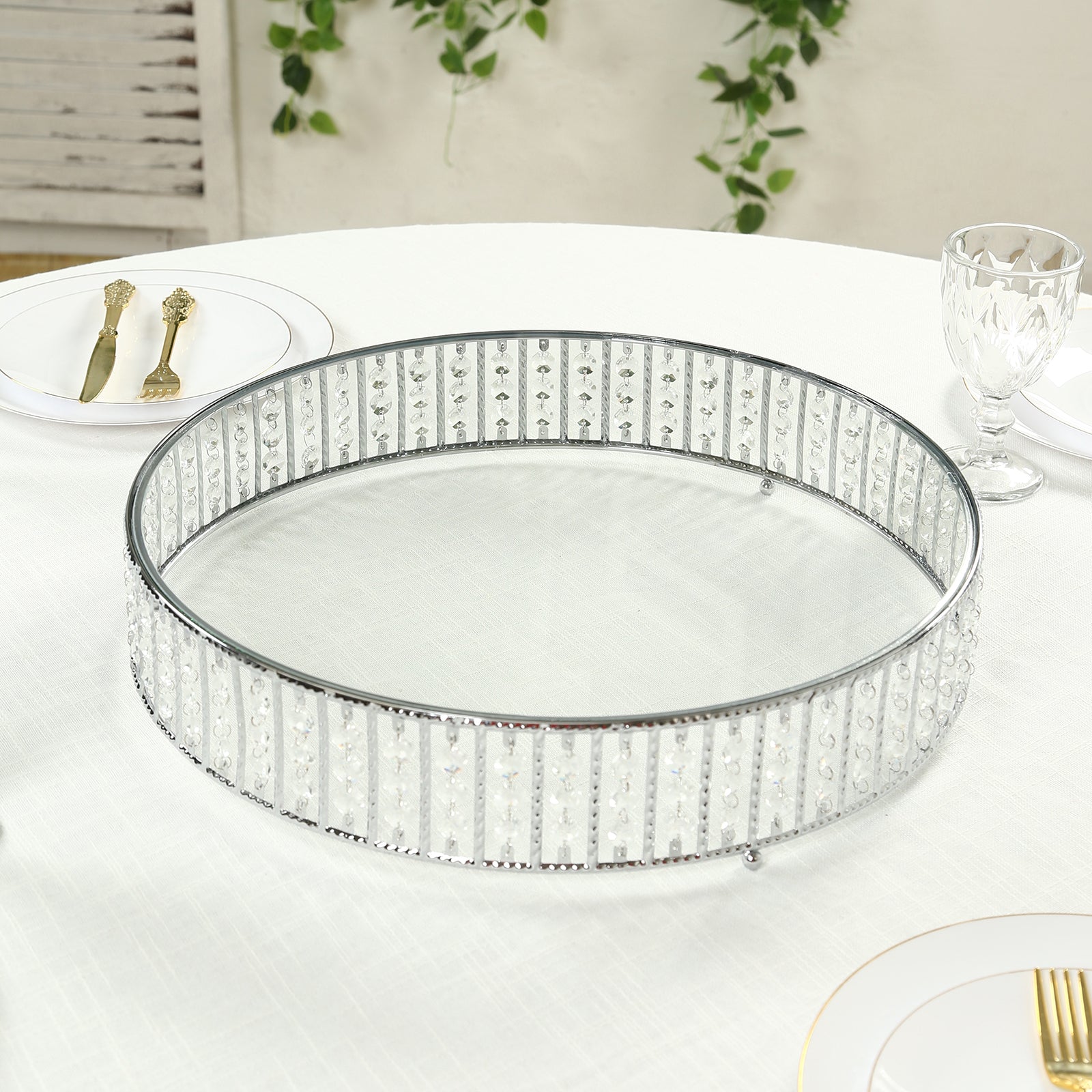 Silver round cake stand with hanging crystals and glass top.