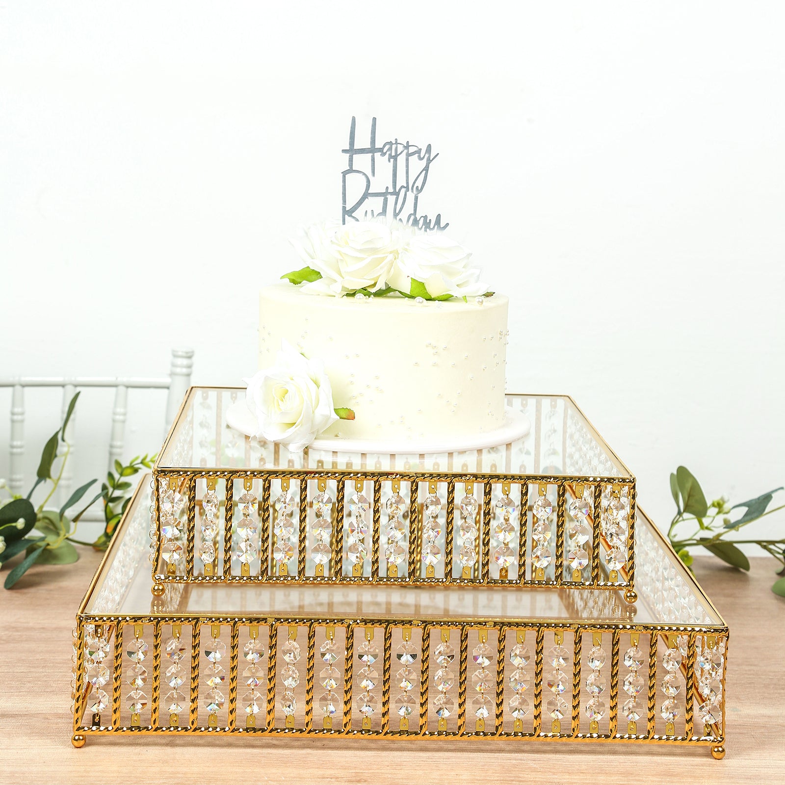 Gold cake stand with hanging crystal beads and glass top, perfect for desserts.