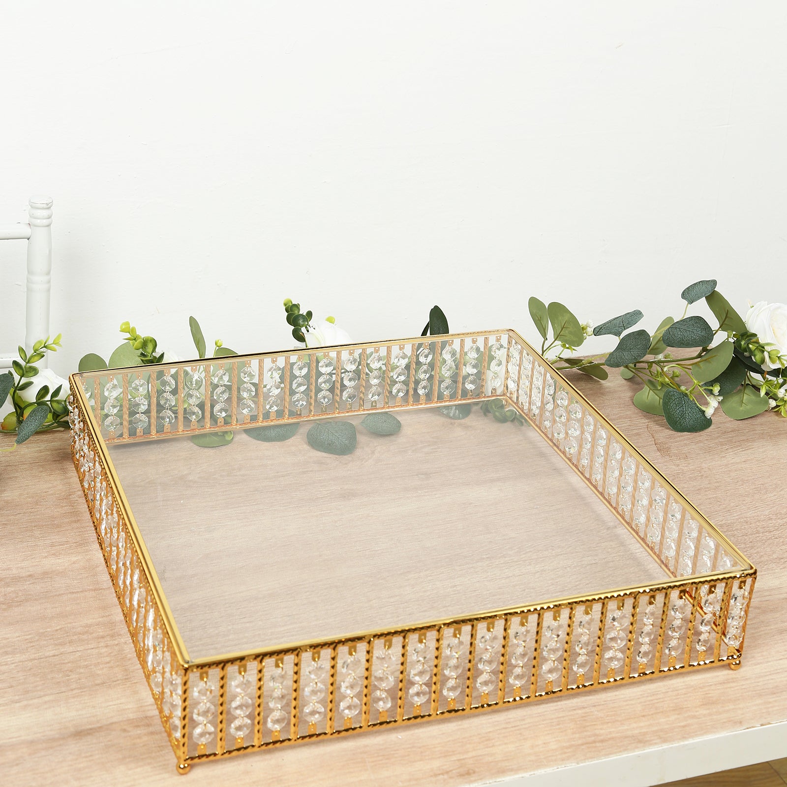 Gold square cake stand with hanging crystal beads and glass top.