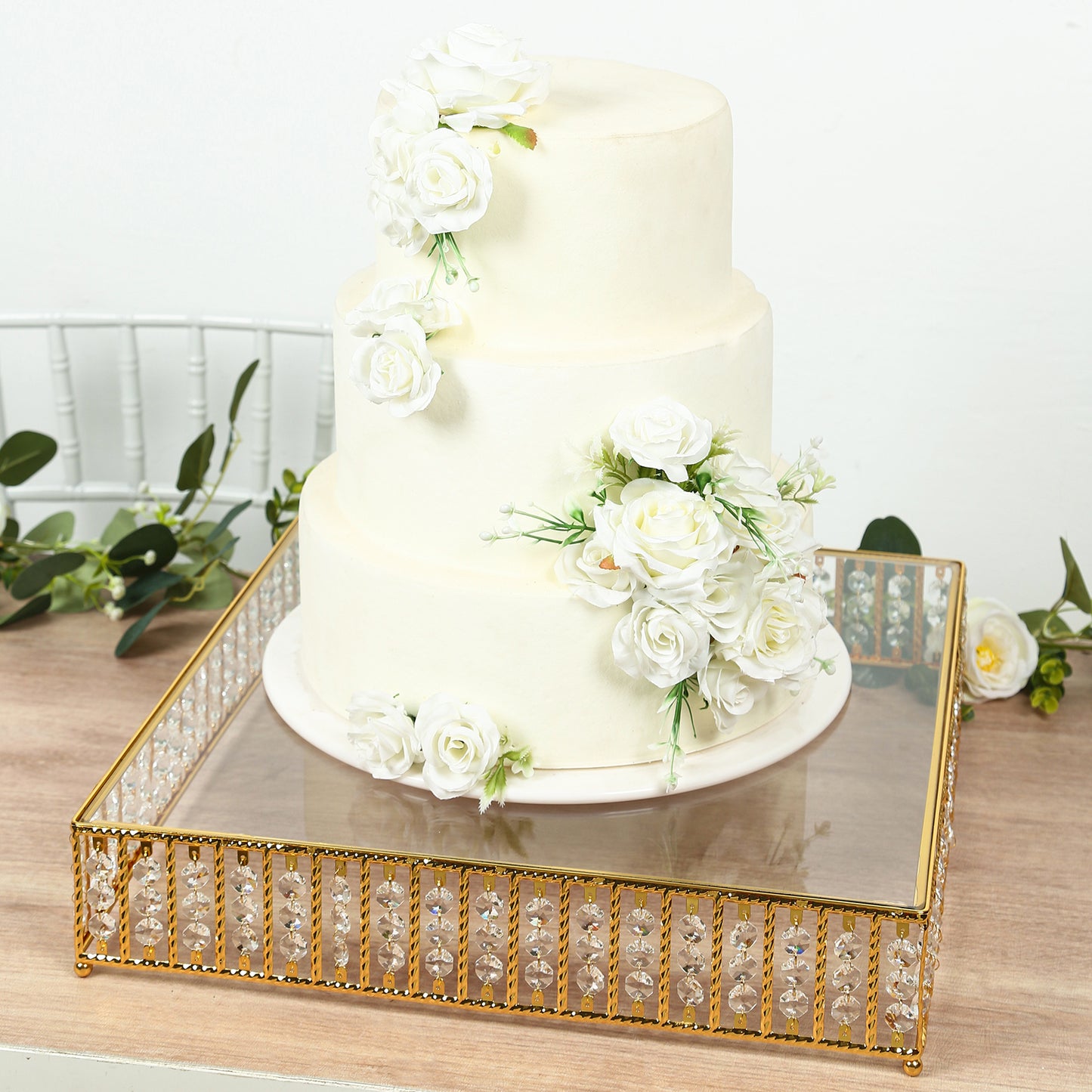 Gold cake stand with hanging crystal beads and glass top, perfect for desserts.