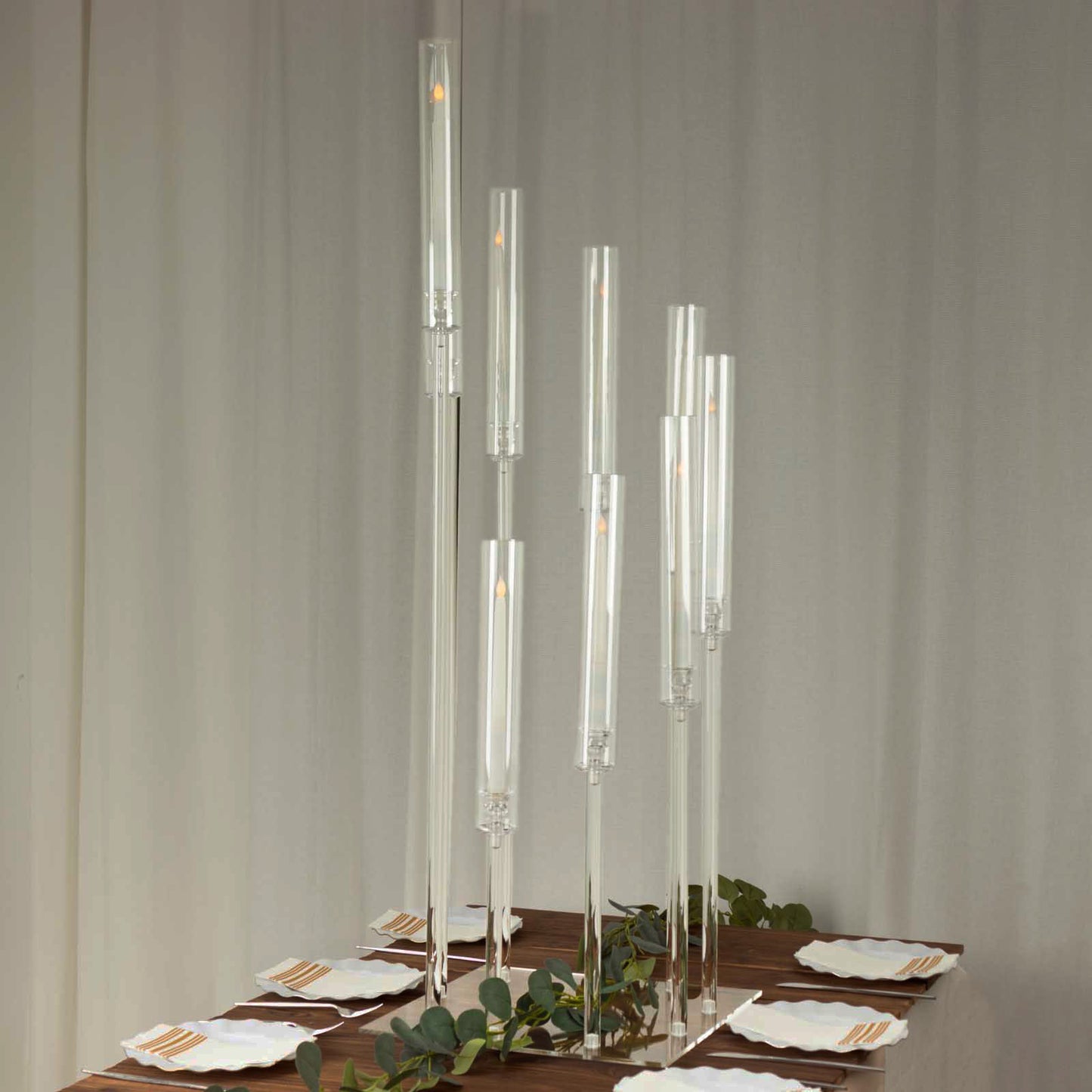 Clear acrylic candelabra with 9 arms, 4ft tall, on a dining table.