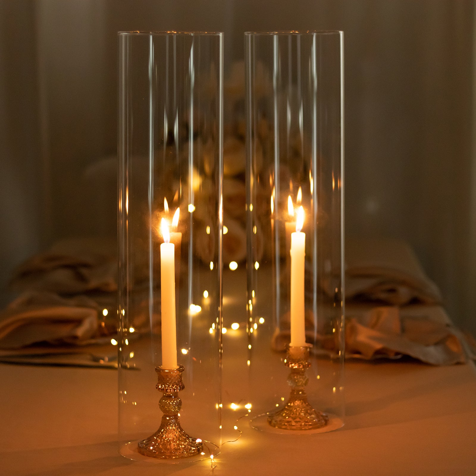 Clear candelabra candle holders with open ends and pillar candles.