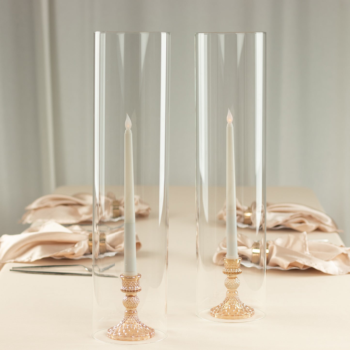 Clear candelabra candle holders with glass shades and open ends.