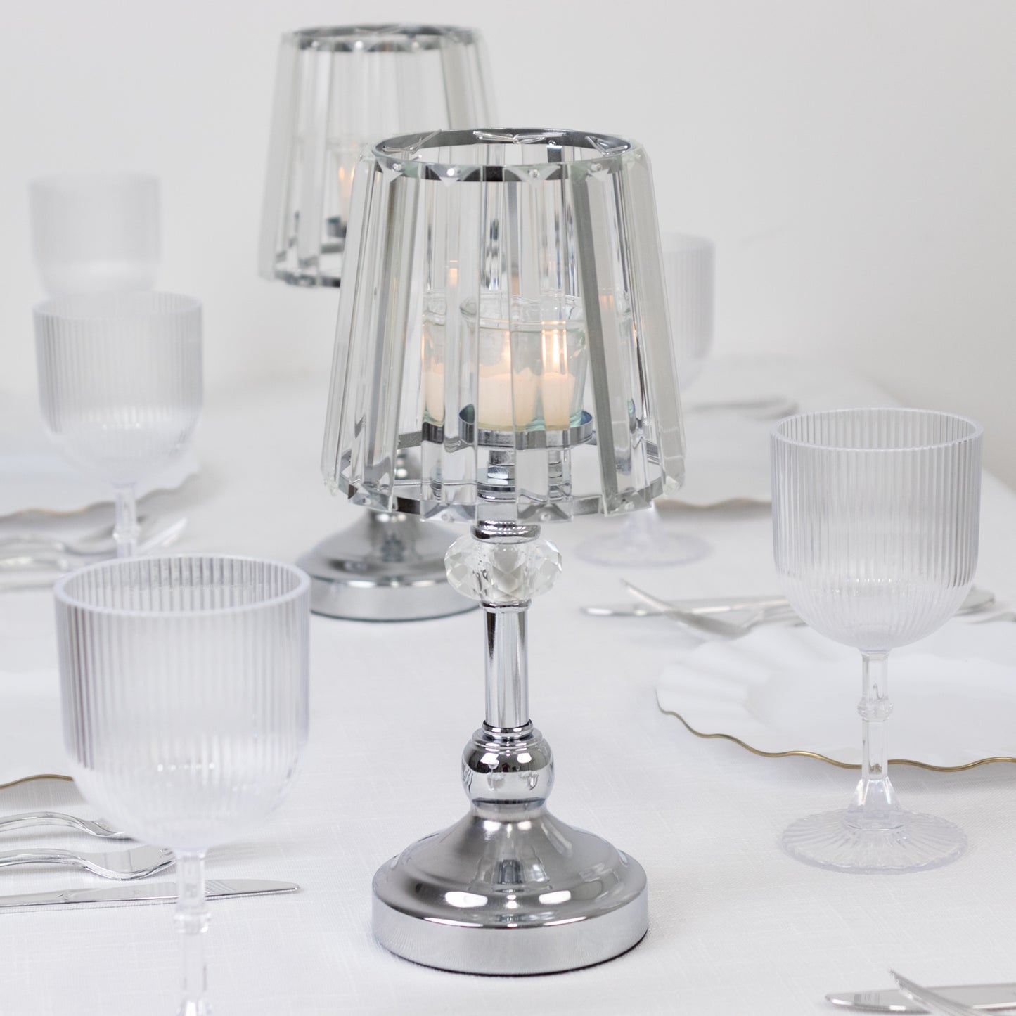 Silver crystal pendant candle holders on a table setting.