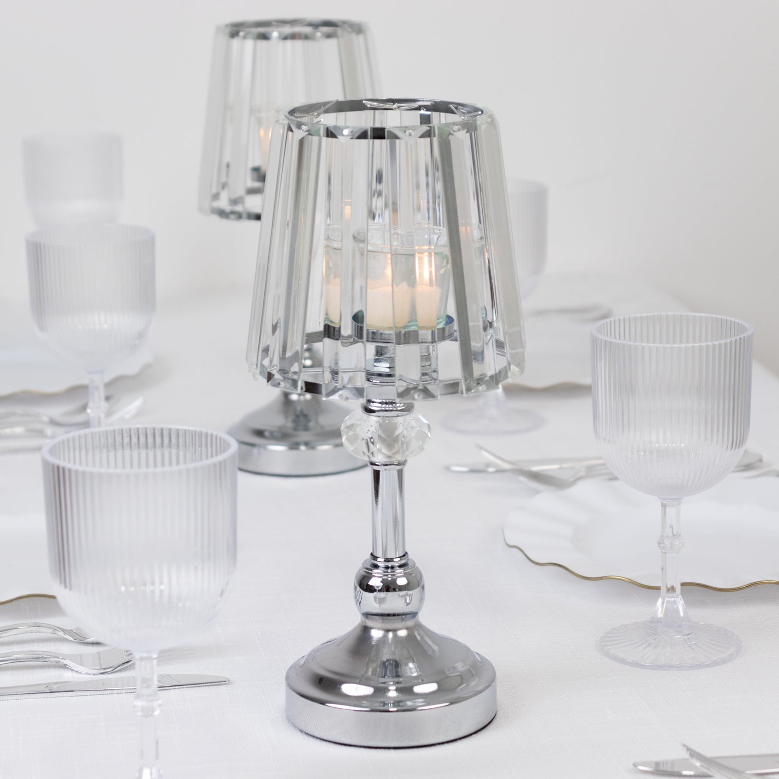 Silver crystal pendant candle holders on a table setting.