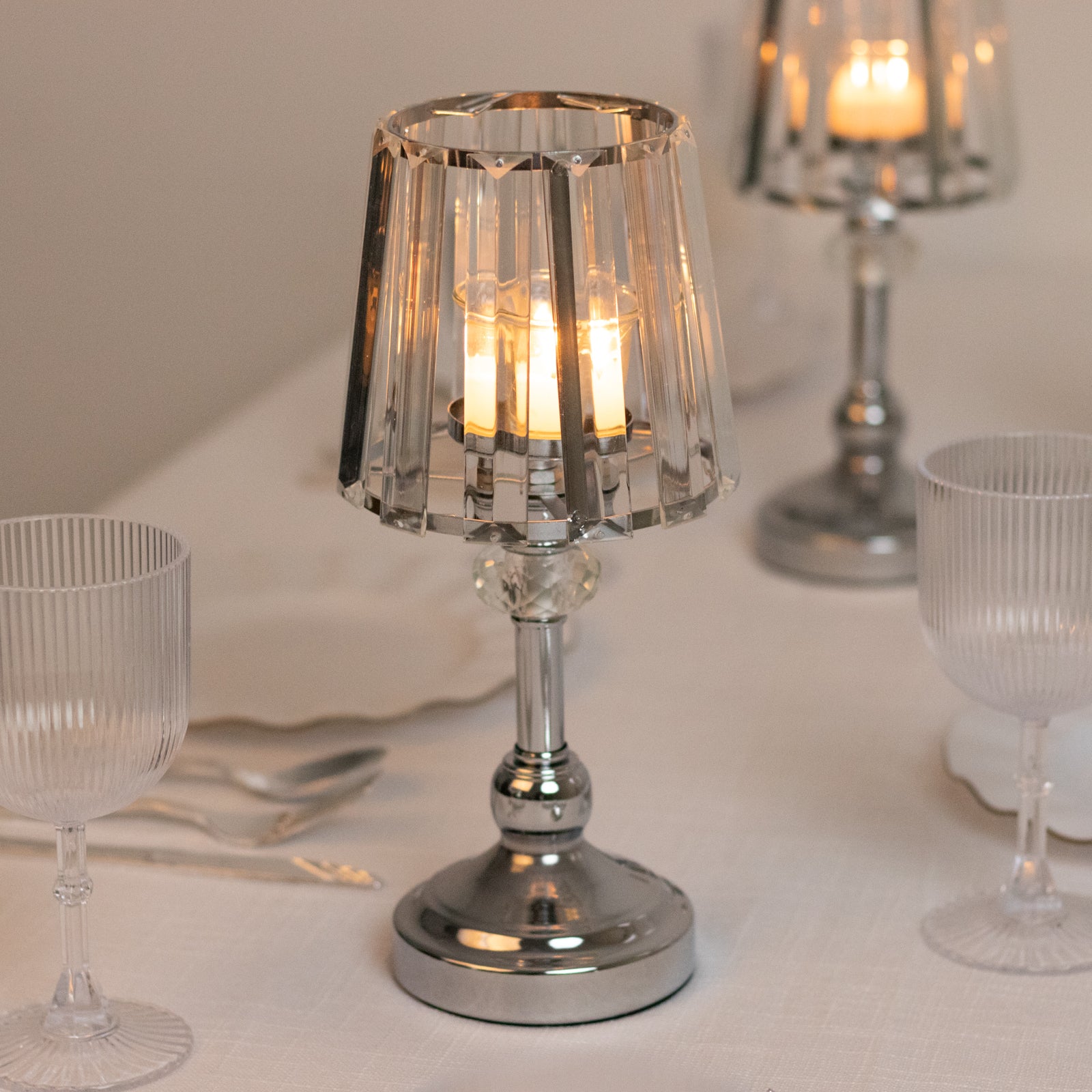 Silver crystal pendant candle holders for elegant table centerpieces.